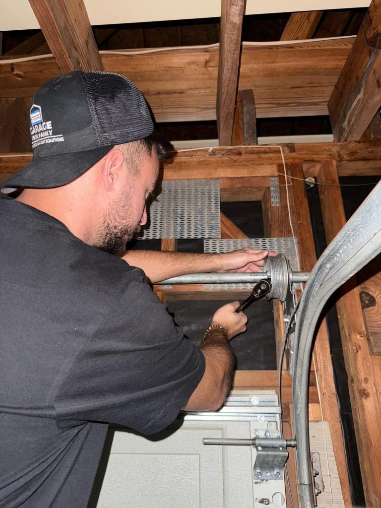 Garage Door Family technician re-seating a lift cable on the drum of a garage door