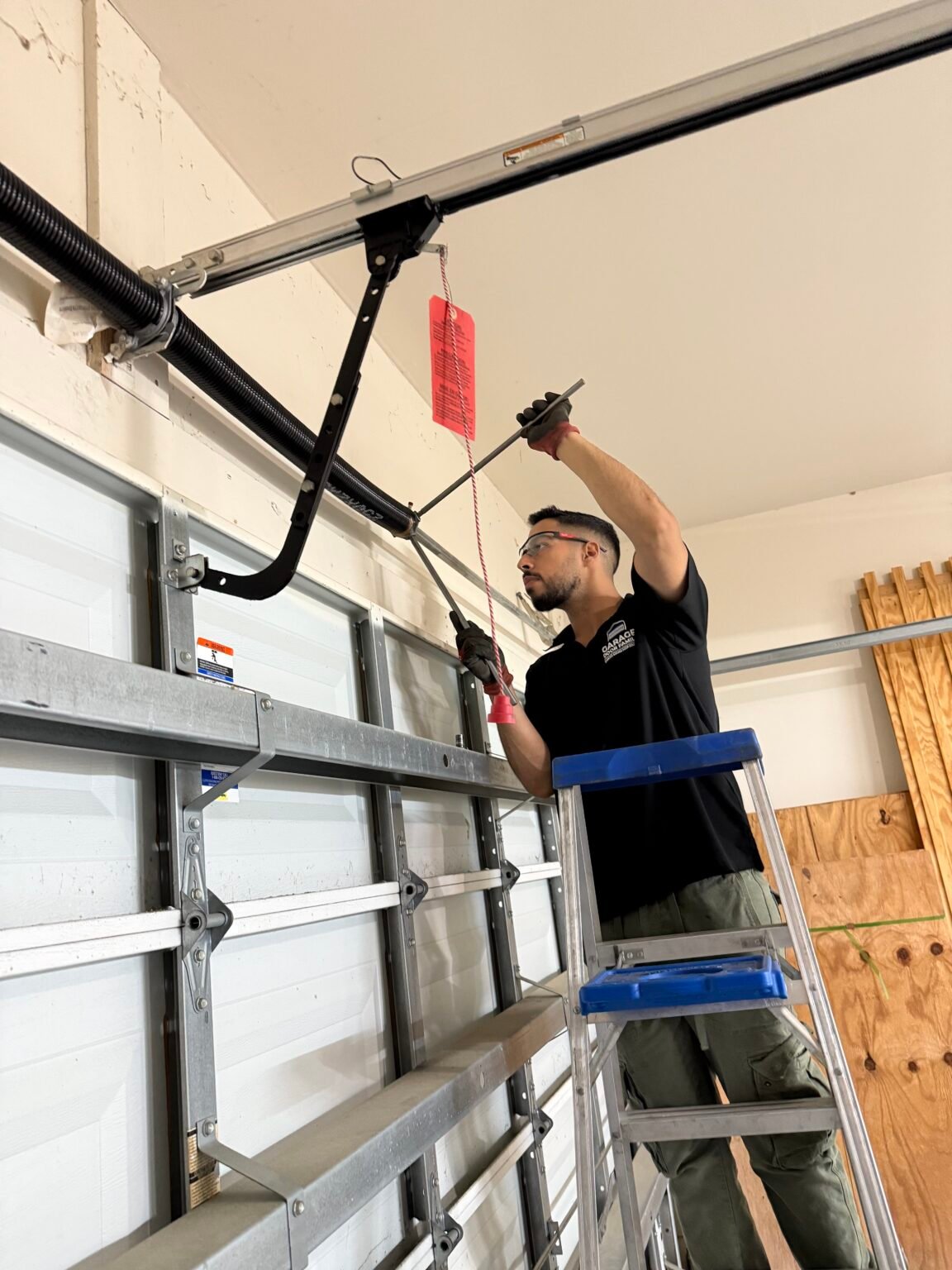 Garage Door Family technician winding a new torsion spring on a garage door in Katy, TX
