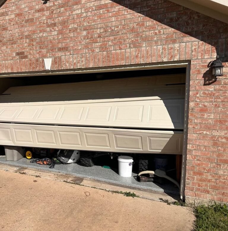 Garage door jammed halfway open at an angle on a brick home in the Houston area